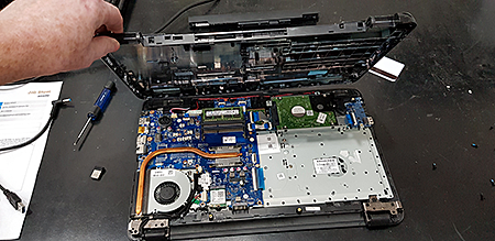 Technician opening a laptop for a service